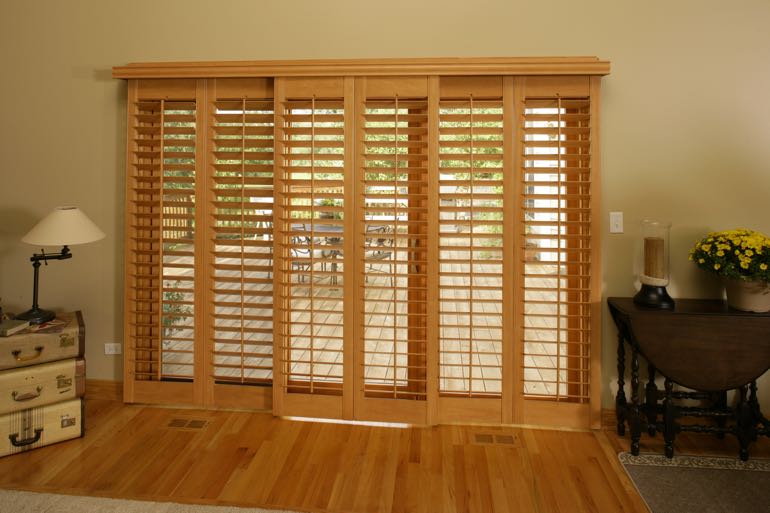 Wood shutters on sliding door leading to full porch.